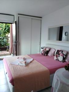 泰斯Apartments by the sea Stanici, Omis - 4585的一间卧室配有一张带粉色床单的床和一扇窗户。