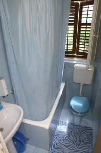 特雷斯塔尼克Apartments by the sea Trstenik, Peljesac - 4511的浴室设有蓝色的卫生间和浴帘