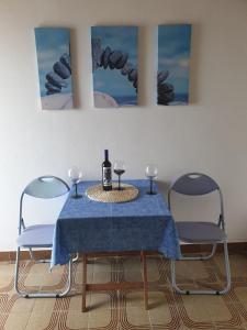 PotomjeStudio Dingac - Potocine 4533a的一张桌子、两把椅子和一瓶葡萄酒