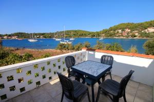 尼亚卢卡Seaside holiday house Cove Gradina, Korcula - 4457的阳台配有桌椅,享有水景