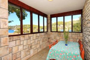 尼亚卢卡Seaside holiday house Cove Gradina, Korcula - 4457的客房设有桌椅和窗户。