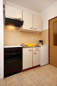 拉茨斯切Apartment Kneza 4342a的厨房配有黑烤箱和白色家电