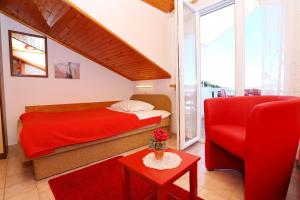 拉茨斯切Apartment Racisce 4360a的一间卧室配有红色的床和红色椅子