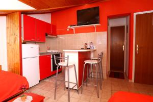 拉茨斯切Apartment Racisce 4360a的一间厨房,配有红色橱柜和酒吧凳子