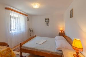 普利兹巴Apartments by the sea Prizba, Korcula - 4479的一间卧室配有一张带灯和窗户的床