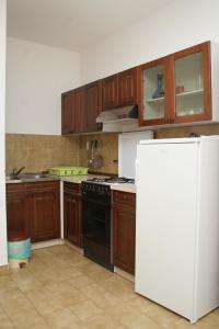 普利兹巴普利斯吧4483c公寓的厨房配有木制橱柜和白色冰箱。