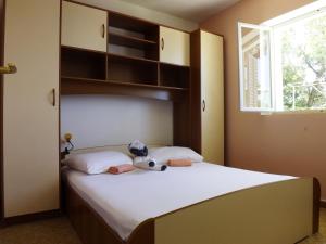 普利兹巴Apartments by the sea Prizba, Korcula - 4483的卧室里设有一张床,上面有一只动物