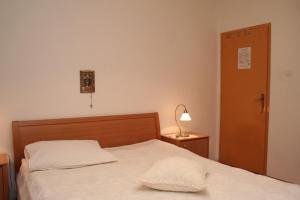 韦伯斯卡Rooms by the sea Vrboska (Hvar) - 4600的一间卧室配有床、灯和门