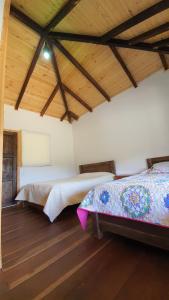 El CocuyBalcones de El Carrizal的铺有木地板的客房内的两张床