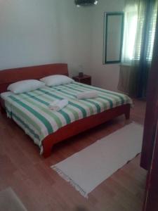 库希斯特Apartments by the sea Kuciste - Perna, Peljesac - 4540的一间卧室配有一张带绿色和白色毯子的床