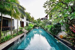 查龙Coco Retreat Phuket Resort and Spa - SHA Plus的度假村中央的游泳池