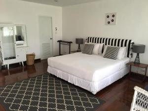 曼谷紫菀9号住宿加早餐旅馆的卧室配有一张白色大床和镜子