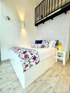 MacanalLa Vista EcoHouse的卧室配有白色床和红色及白色枕头
