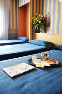 米兰伽达酒店的酒店客房设有两张床和一盘食物