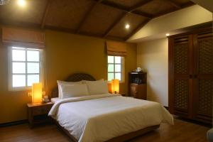 蓬蒂切里里士满酒店的卧室设有一张白色大床和两个窗户。