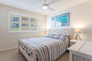 玛志洛珊瑚海公寓 的一间卧室设有一张床和两个窗户。
