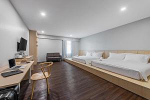 新山Hako Hotel Taman U的酒店客房设有一张大床和一张书桌。