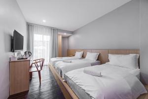 新山Hako Hotel Taman U的酒店客房设有两张床和电视。