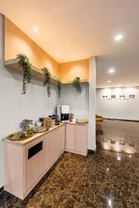 新山Hako Hotel Taman U的厨房配有墙上植物台面