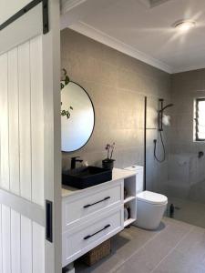 堤维德岬Tweed River Retreat的一间带水槽、卫生间和镜子的浴室
