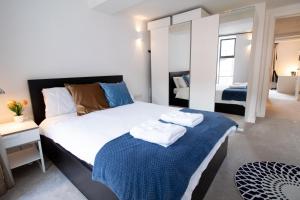 牛津The New52 Oxford by 360Stays - Bespoke 2 Bed Luxury Apartment in the Heart of Oxford City Center with Parking的一间卧室配有一张大床和毛巾