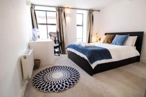 牛津The New52 Oxford by 360Stays - Bespoke 2 Bed Luxury Apartment in the Heart of Oxford City Center with Parking的一间卧室配有一张大床,提供蓝白色的毯子