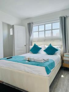 卡塔赫纳Le MARIE B&B的卧室配有带蓝色枕头的大型白色床