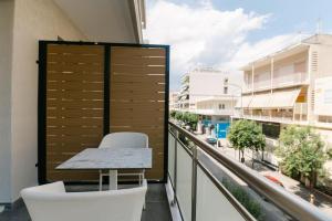 亚历山德鲁波利斯Magico Suites City Heart Luxury Appartments的市景阳台配有桌椅。