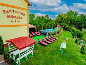 诺瓦齐- 斯特拉尼Pensiunea Mihaela的一个带椅子的度假胜地和一个庭院内的游泳池