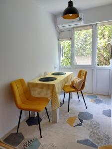 克拉约瓦STUDIO 22的一间带桌子和两把椅子的用餐室