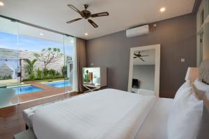 塞米亚克The Daha Luxury Villas的卧室设有白色的床和大窗户