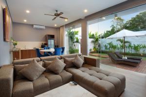 塞米亚克The Daha Luxury Villas的客厅配有棕色沙发和桌子