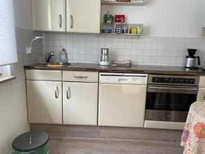 Borgholzhausen2 Zimmer Appartement的厨房配有白色橱柜和炉灶。