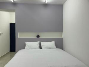 Ḩilf马安公寓的客房内的一张带两个枕头的白色床