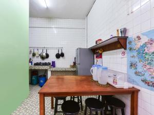 关丹SPOT ON 89872 Kuantan Backpackers的厨房配有木桌和黑色椅子