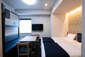 东京Minn Kasai的酒店客房设有两张床和一张桌子。