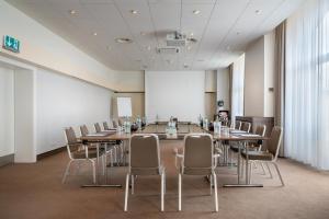 埃森埃森汉德尔斯霍夫精选酒店的一间会议室,配有长桌子和椅子