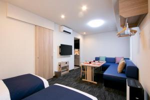 东京Minn 葛西 酒店公寓(Minn Kasai)的酒店客房配有蓝色的沙发和桌子