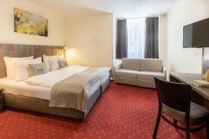 科隆莱奥科隆老城新奇酒店的酒店客房设有一张大床和一张书桌。