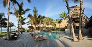 曼克拉马库拉艾维纳酒店的一个带躺椅和棕榈树的度假游泳池