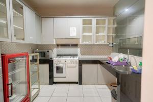 雅加达RedDoorz Premium near RS Pondok Indah La Maison的厨房配有白色橱柜和白色家电