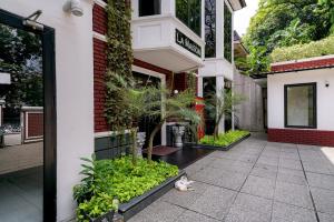 雅加达RedDoorz Premium near RS Pondok Indah La Maison的一只猫躺在楼前的地面上