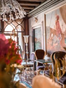 威尼斯EGO' Boutique Hotel - The Silk Road的一间带吊灯和桌椅的用餐室