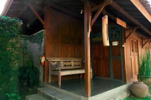 日惹Rumah Tembi的坐在房子外的木凳