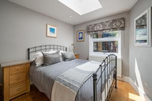 伦敦JOIVY 2-bed flat with garden in Battersea的一间卧室设有一张床和一个窗口