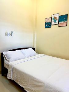 Ấp Bình HưngT's House Motel的卧室配有一张床,墙上有三幅照片