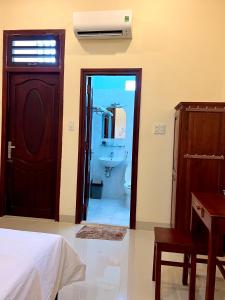 Ấp Bình HưngT's House Motel的卧室设有通往浴室的门