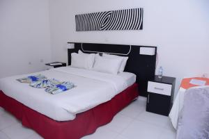 KayonzaSilent Hill Hotel Kayonza的一间卧室配有一张大床和毛巾