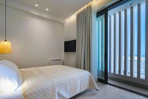 海若克利欧KoNoSo Luxury Apartments的一间卧室设有一张床和一个大窗户