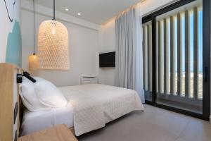 海若克利欧KoNoSo Luxury Apartments的卧室设有白色的床和大窗户